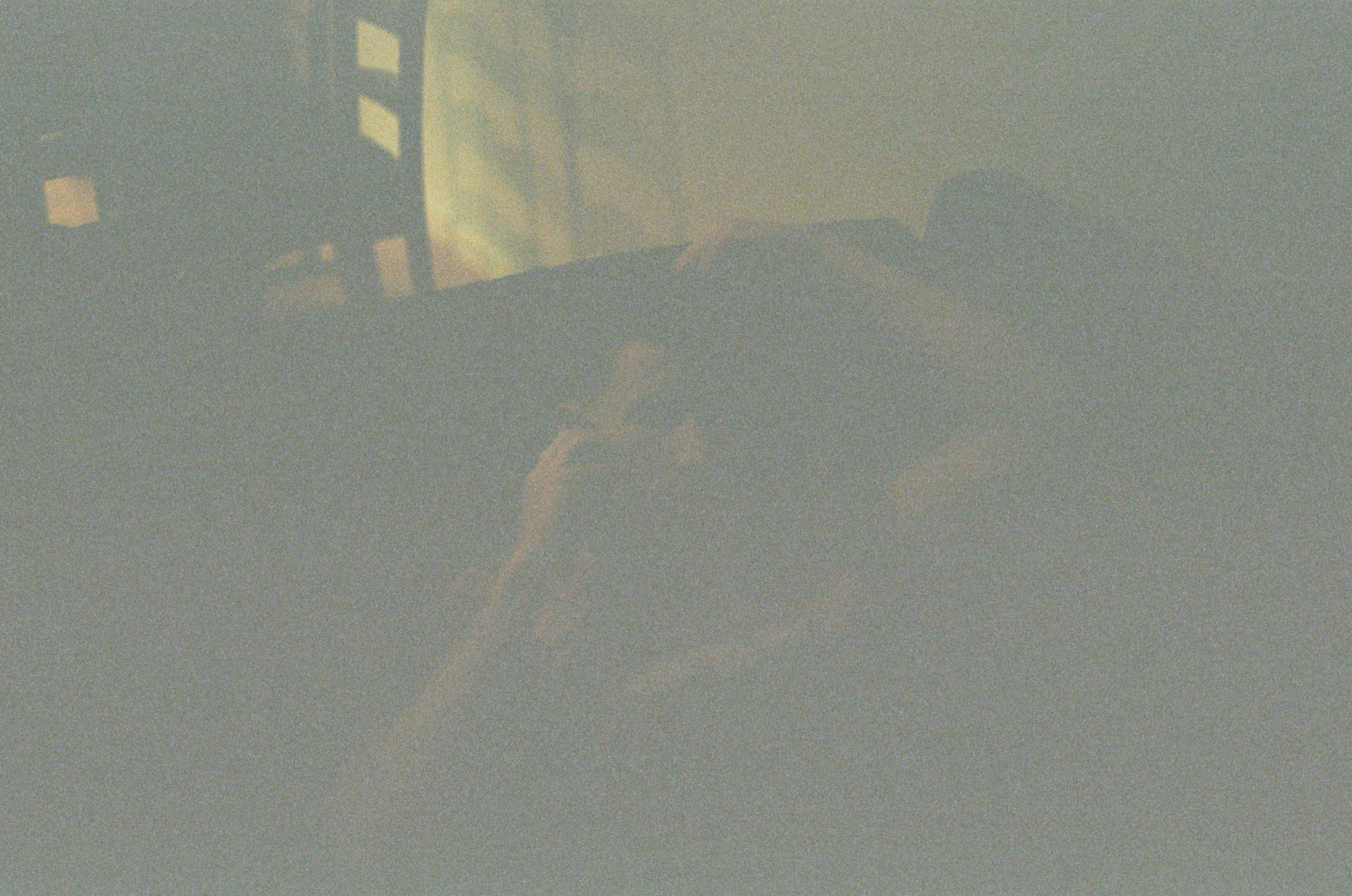 Underexposed interior frame with faint window light